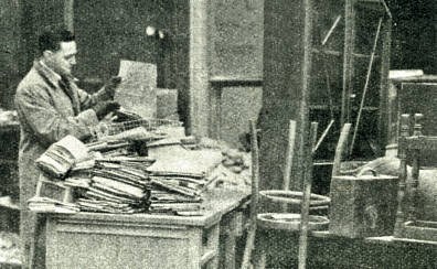 A worker sorting out paperwork in the office ready to resume war production.