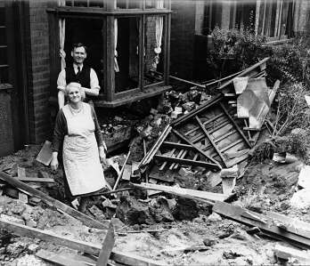 A couple standing next to their bomb damaged house