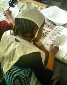 A school pupil recreating the old alphabet