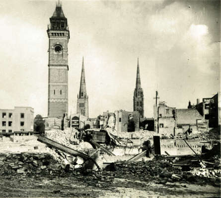 The old Market Tower and two spires seen across the ruined city centre.